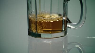 a glass mug filled with liquid on top of a table