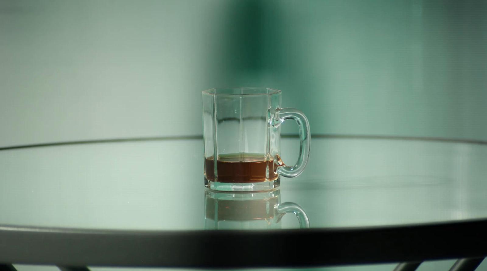 a glass of liquid sitting on top of a table