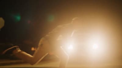 a man riding a skateboard down a street at night
