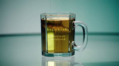 a glass mug of tea on a reflective surface