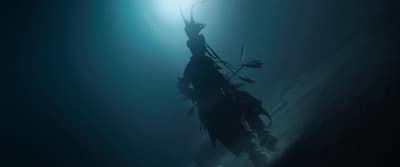 a person floating in the water with a light shining on them