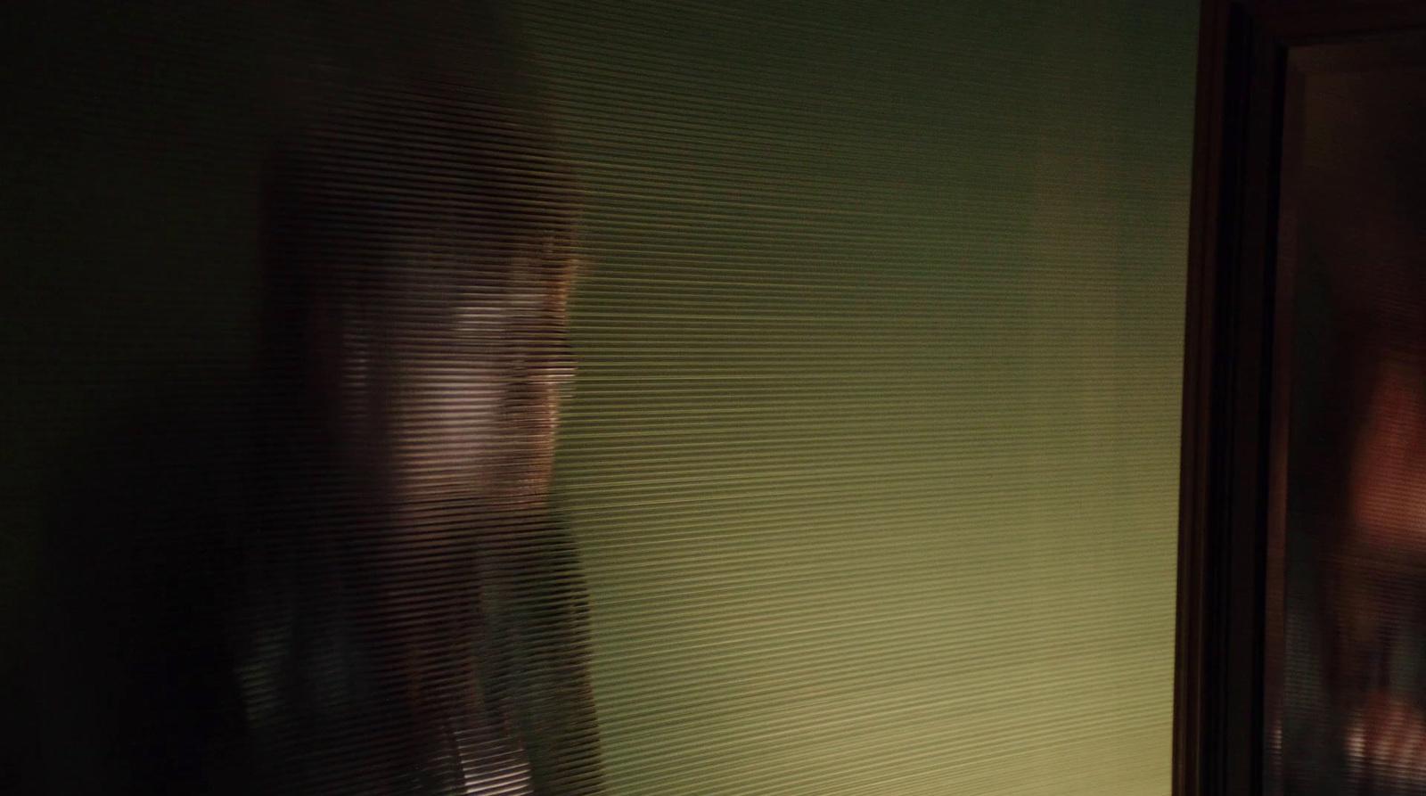 a blurry photo of a woman's reflection in a bathroom mirror