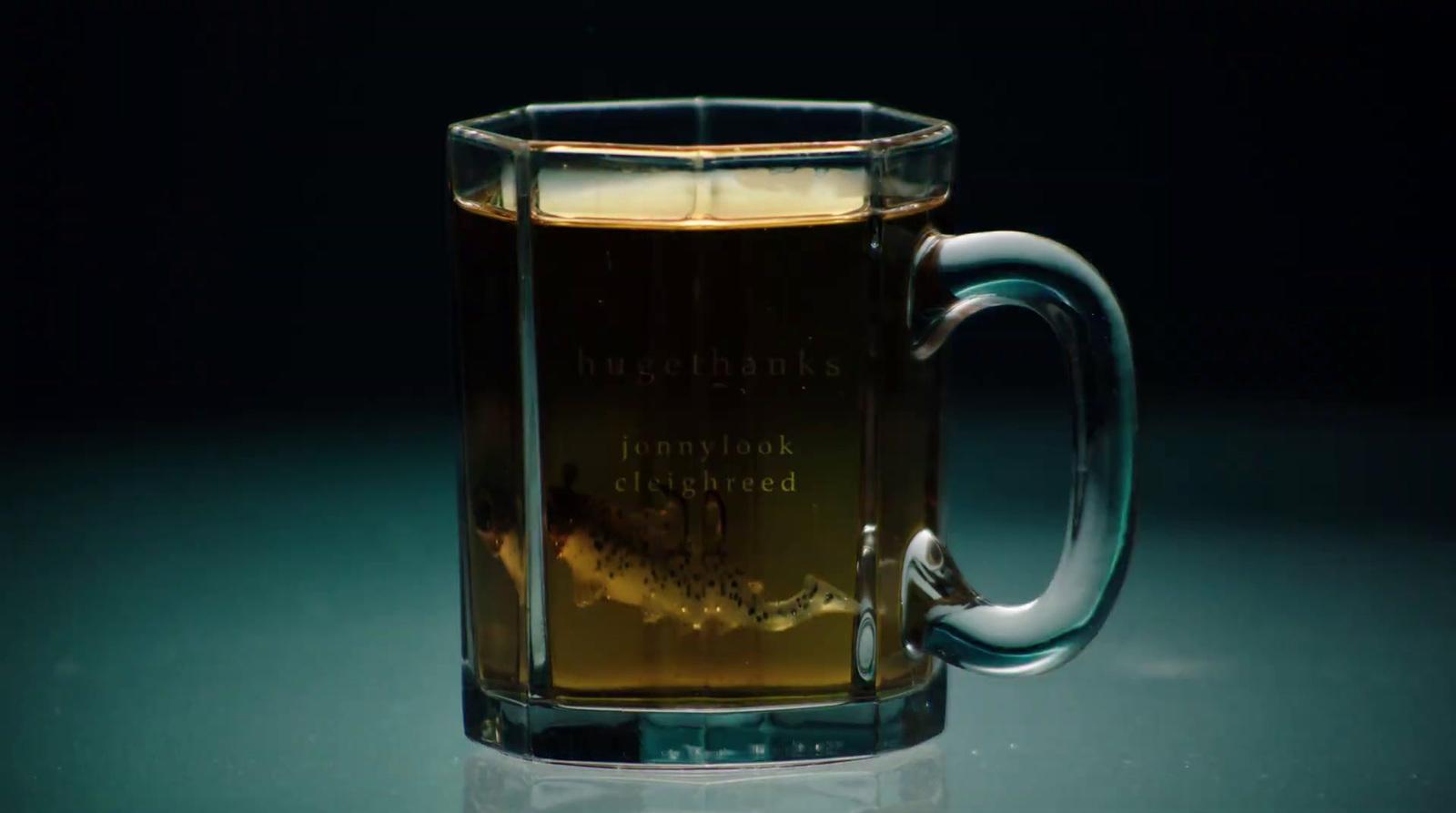 a glass mug filled with liquid sitting on a table