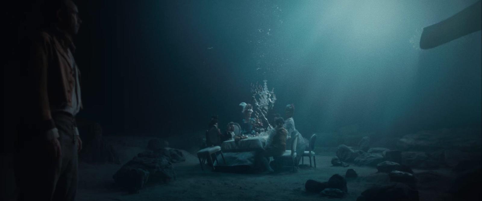 a group of people sitting around a table under water