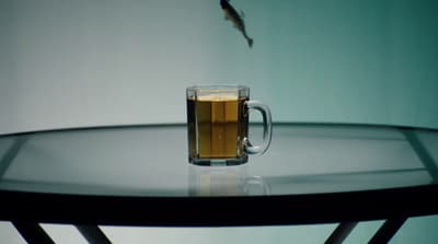 a glass of beer sitting on top of a table
