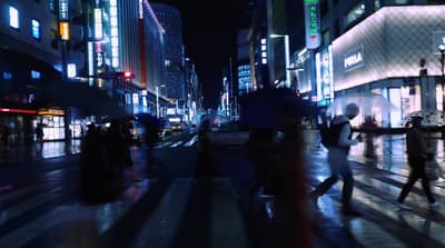a group of people walking across a street at night