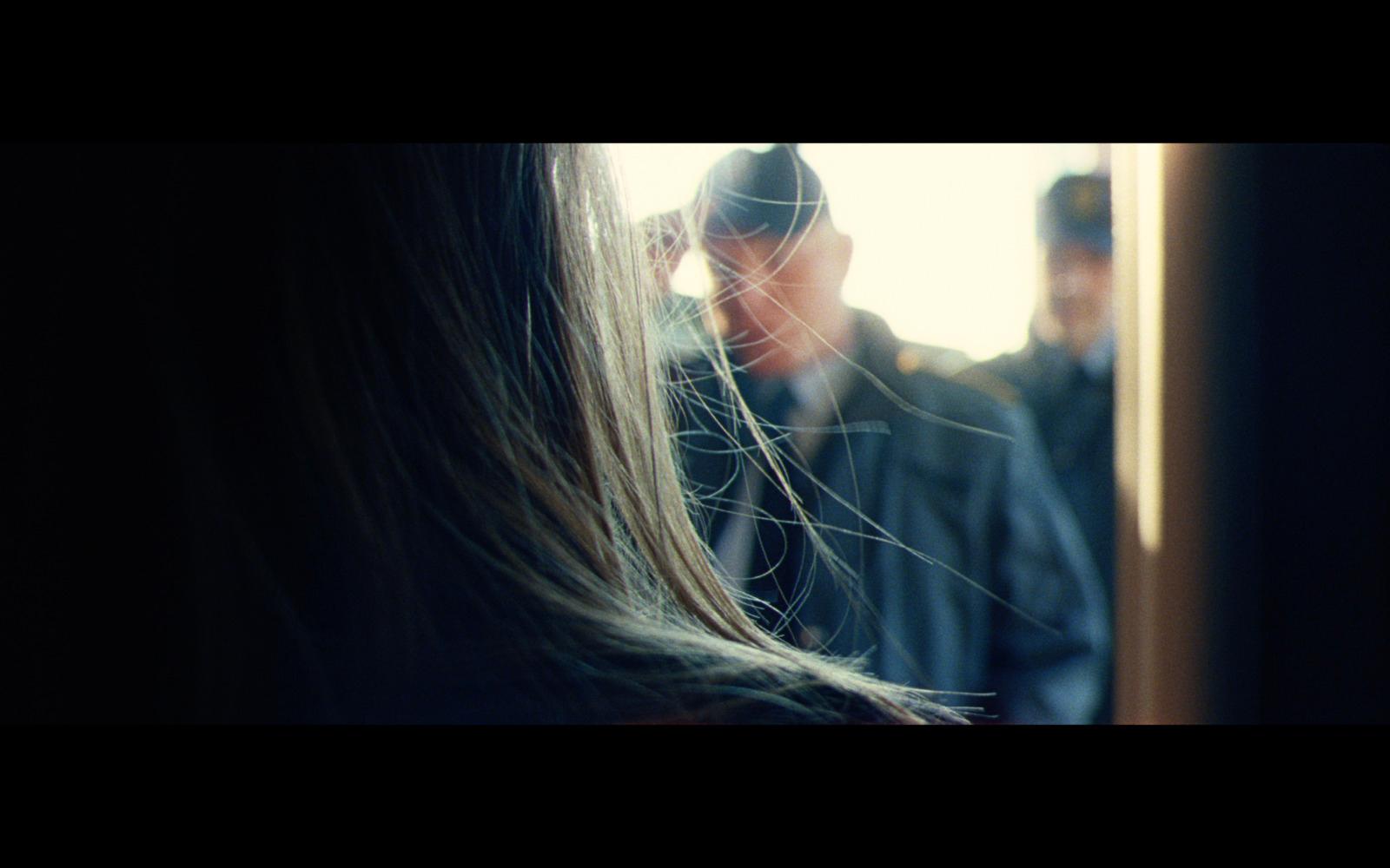a woman with long hair standing in front of a man