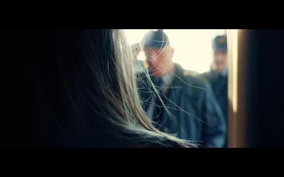 a woman with long hair standing in front of a man