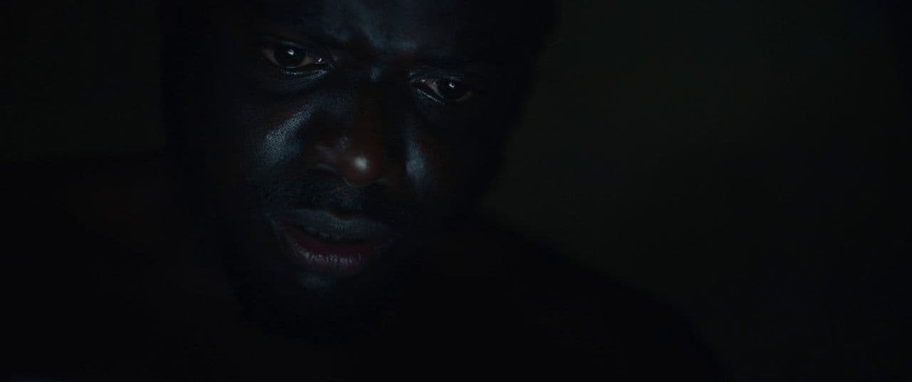 a man in the dark looking at his cell phone