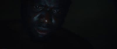 a man in the dark looking at his cell phone