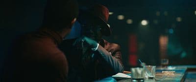 a man sitting at a bar talking on a cell phone