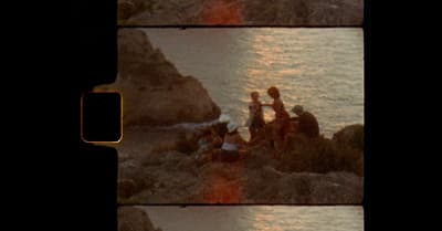 a group of people sitting on top of a rocky beach