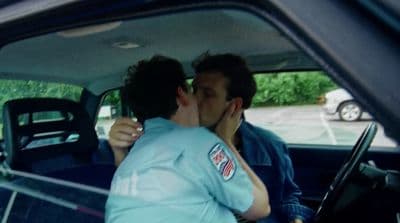 a man kissing a woman in the back of a car