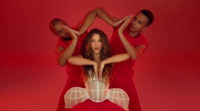 a woman in a red dress is surrounded by three men