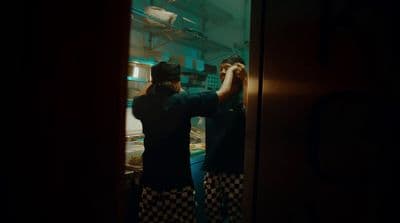 a couple of people that are standing in a kitchen