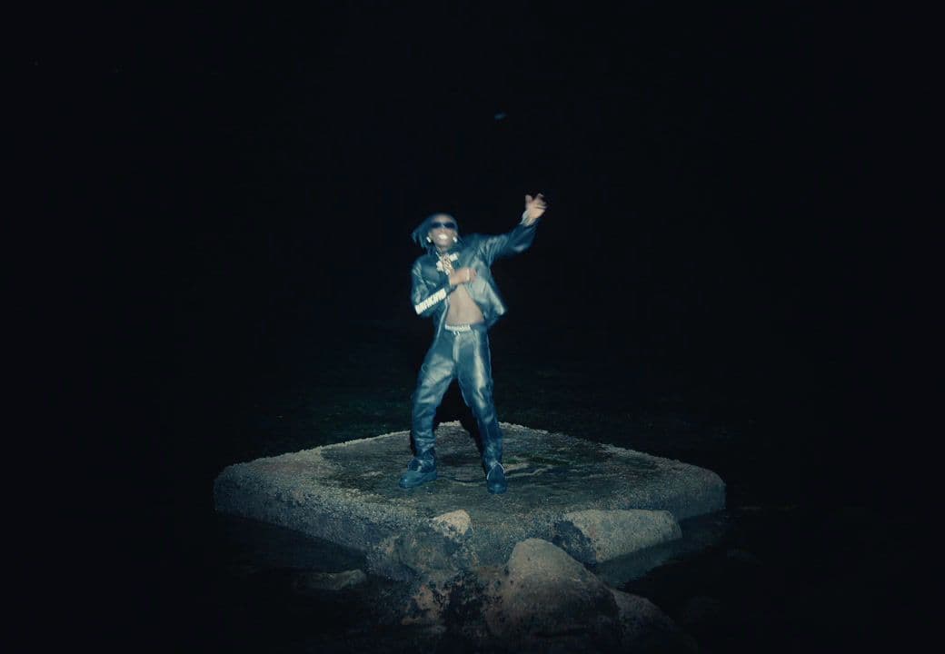 a statue of a man standing on a rock in the dark