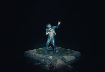 a statue of a man standing on a rock in the dark