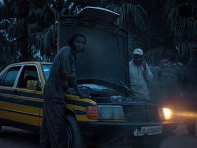 a man standing next to a car with its hood open