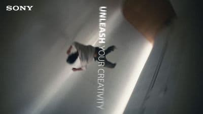a man walking down a hallway next to a white wall