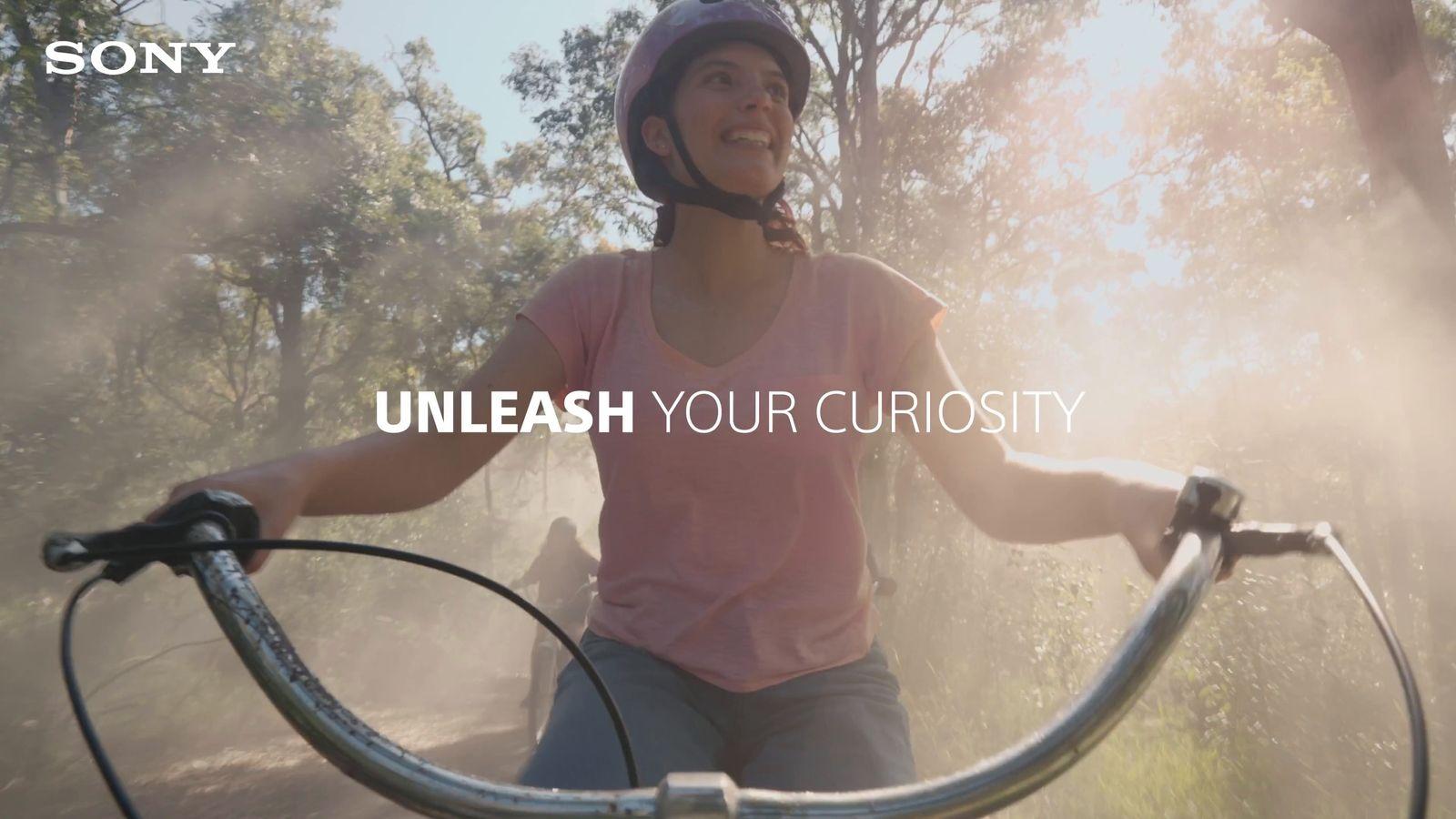 a person riding a bike with the words unleash your curiosity