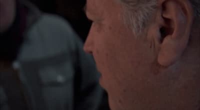 a close up of a person wearing a suit and tie