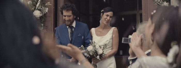 a bride and groom walking out of a church