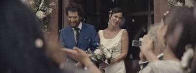 a bride and groom walking out of a church