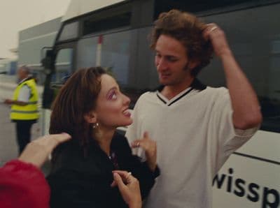 a man standing next to a woman near a bus