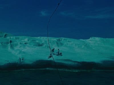 a group of people standing on top of a snow covered slope