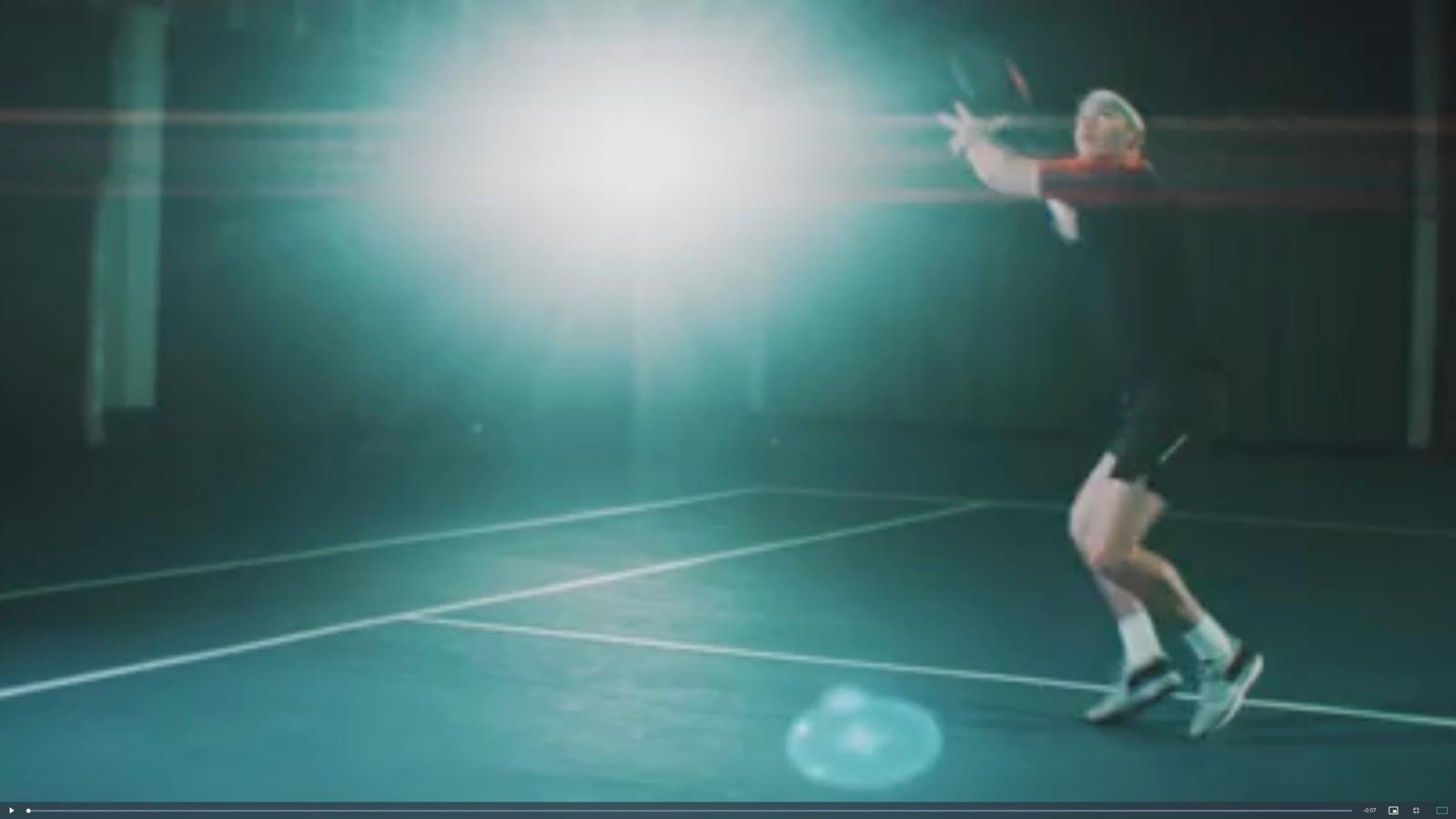 a man standing on a tennis court holding a racquet