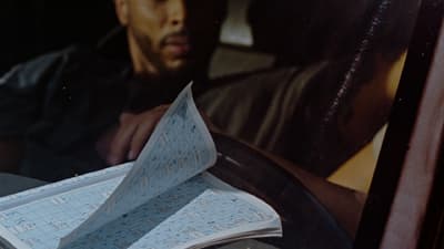 a man sitting in a car holding a piece of paper