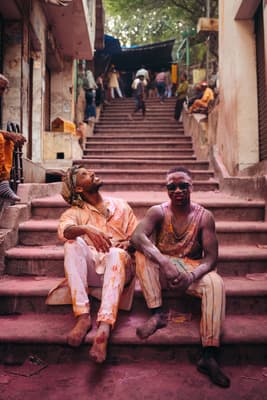 a couple of men sitting on top of a set of stairs