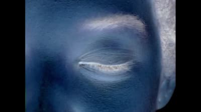 a close up of a person's face with blue paint on it