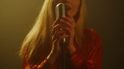 a woman with long blonde hair holding a microphone