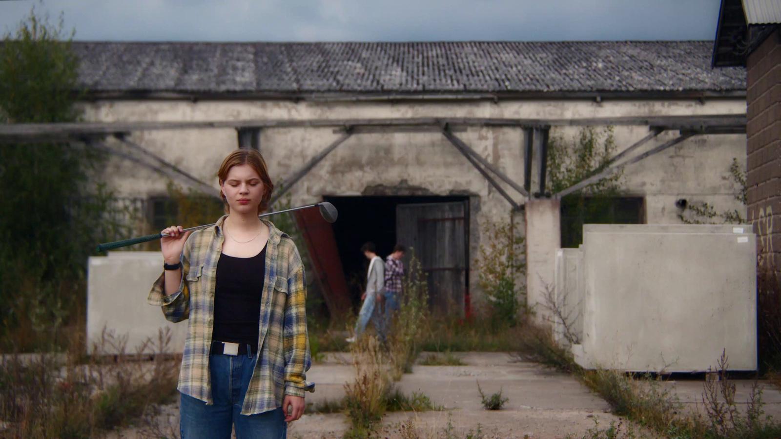 a woman standing in front of a building holding a microphone
