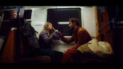 a man and a woman sitting on a train