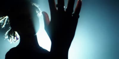 a silhouette of a woman holding her hands up in the air