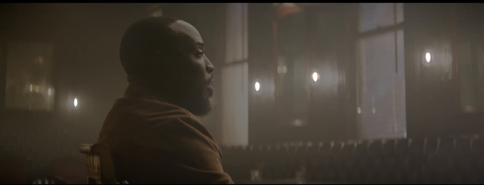 a man standing in a dark room in front of a window