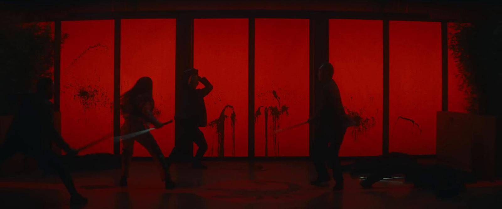 a group of people standing in front of a red wall