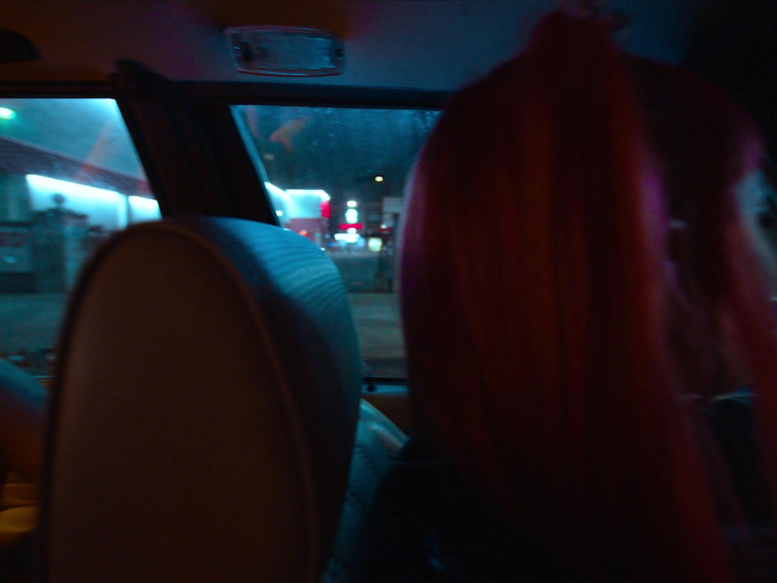a woman with red hair sitting in a car