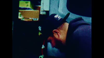 a man sleeping on a plane with a hat on