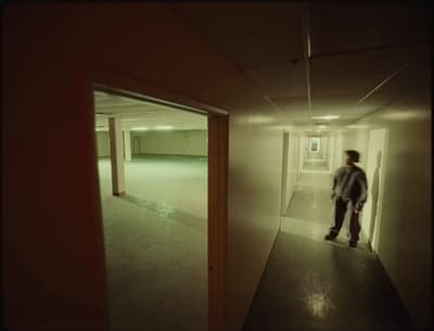 a man standing in a hallway in an empty building