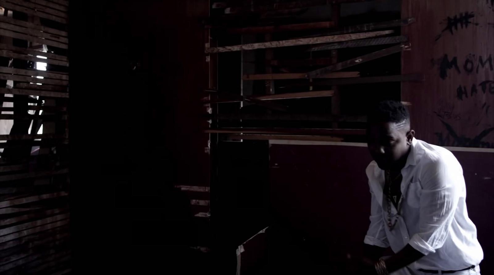 a man standing in a dark room next to a wall