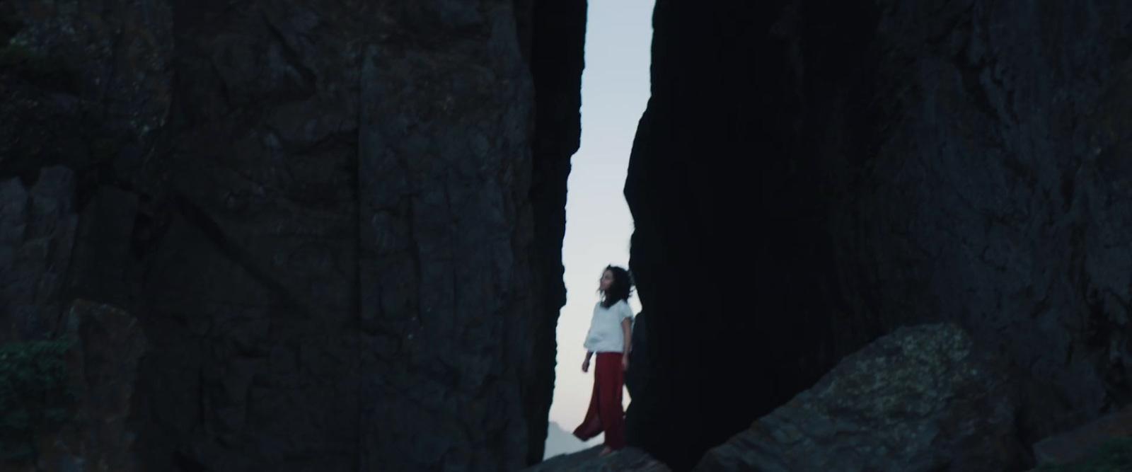 a woman standing in between two large rocks