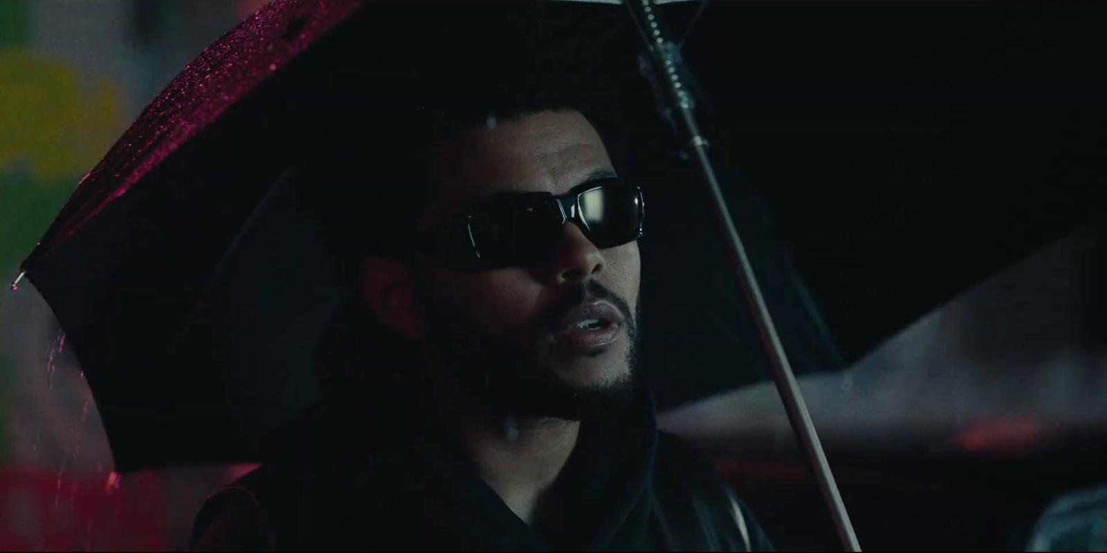 a man wearing sunglasses and holding an umbrella