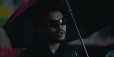 a man wearing sunglasses and holding an umbrella