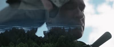 a reflection of a man holding a baseball bat