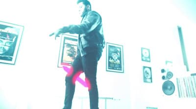 a man standing in a living room holding a pink object