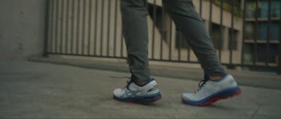 a person standing on a sidewalk with their foot on a skateboard