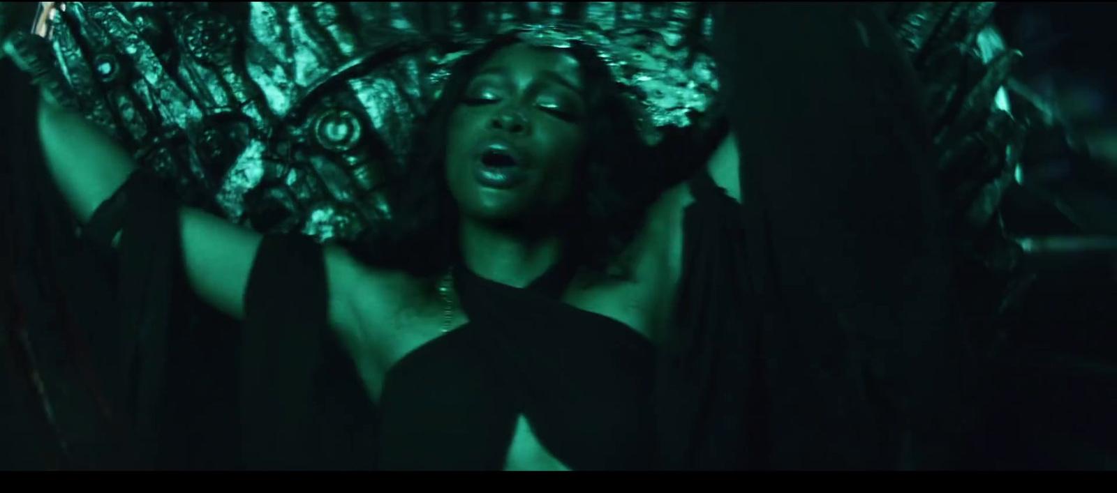 a woman in a black dress laying on her back